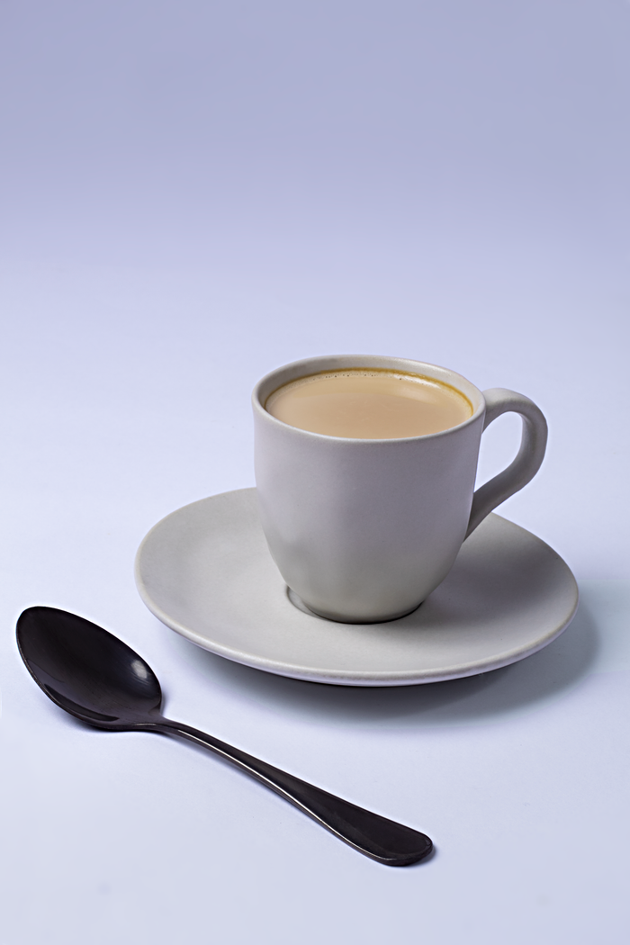 Elegant coffee cup with a spoon on white background, perfect for cafe promotions.