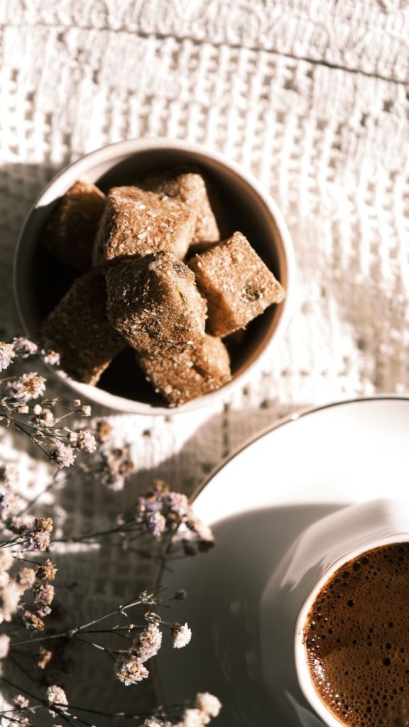 Crafting Captivating Headlines: Your awesome post title goes here Overhead shot of a coffee cup and brown sugar cubes on a textured surface with dried flowers.