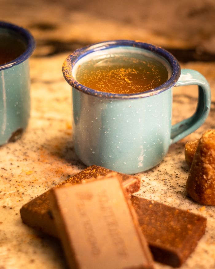 Authentic Mexican Cafe de Olla with cinnamon sticks and chocolate, served in blue enamel mugs.